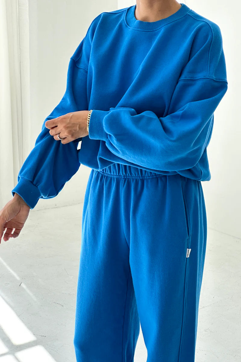 Person wearing a blue tracksuit against a white background